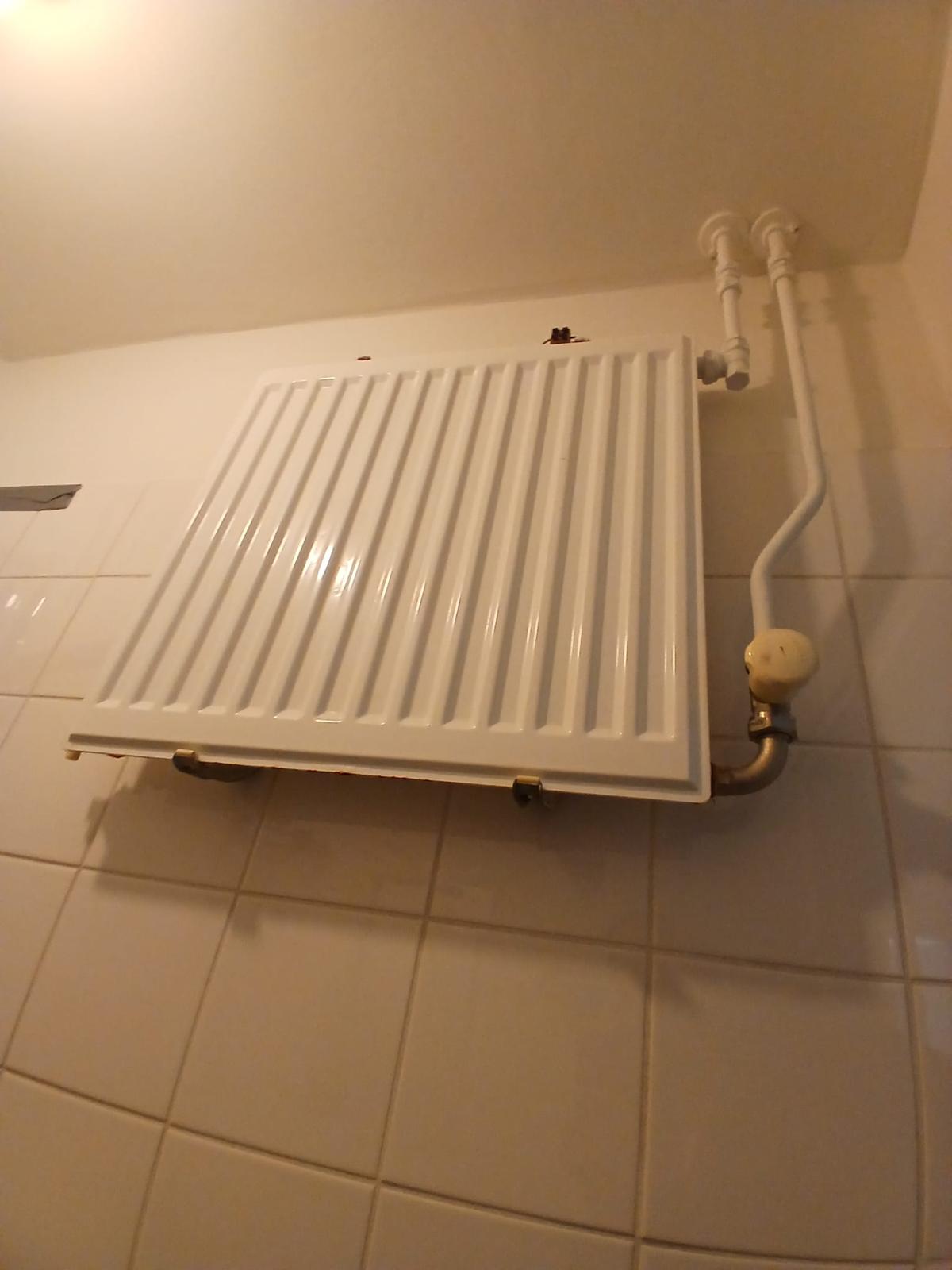 Radiator met nieuw aangesloten leidingen en kraan