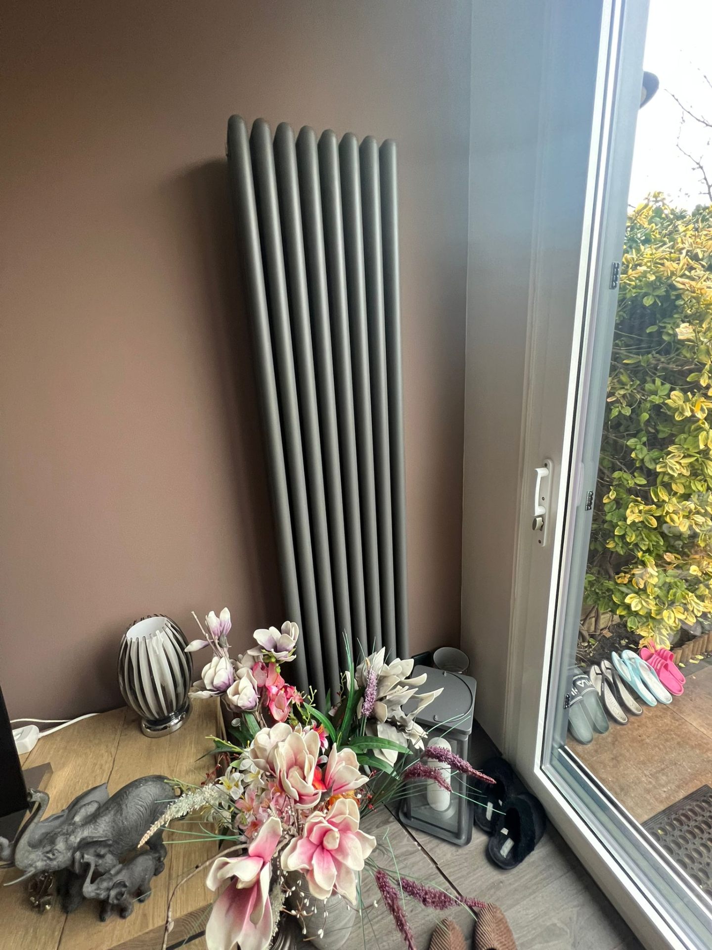 Verticale designradiator geplaatst tegen een wand