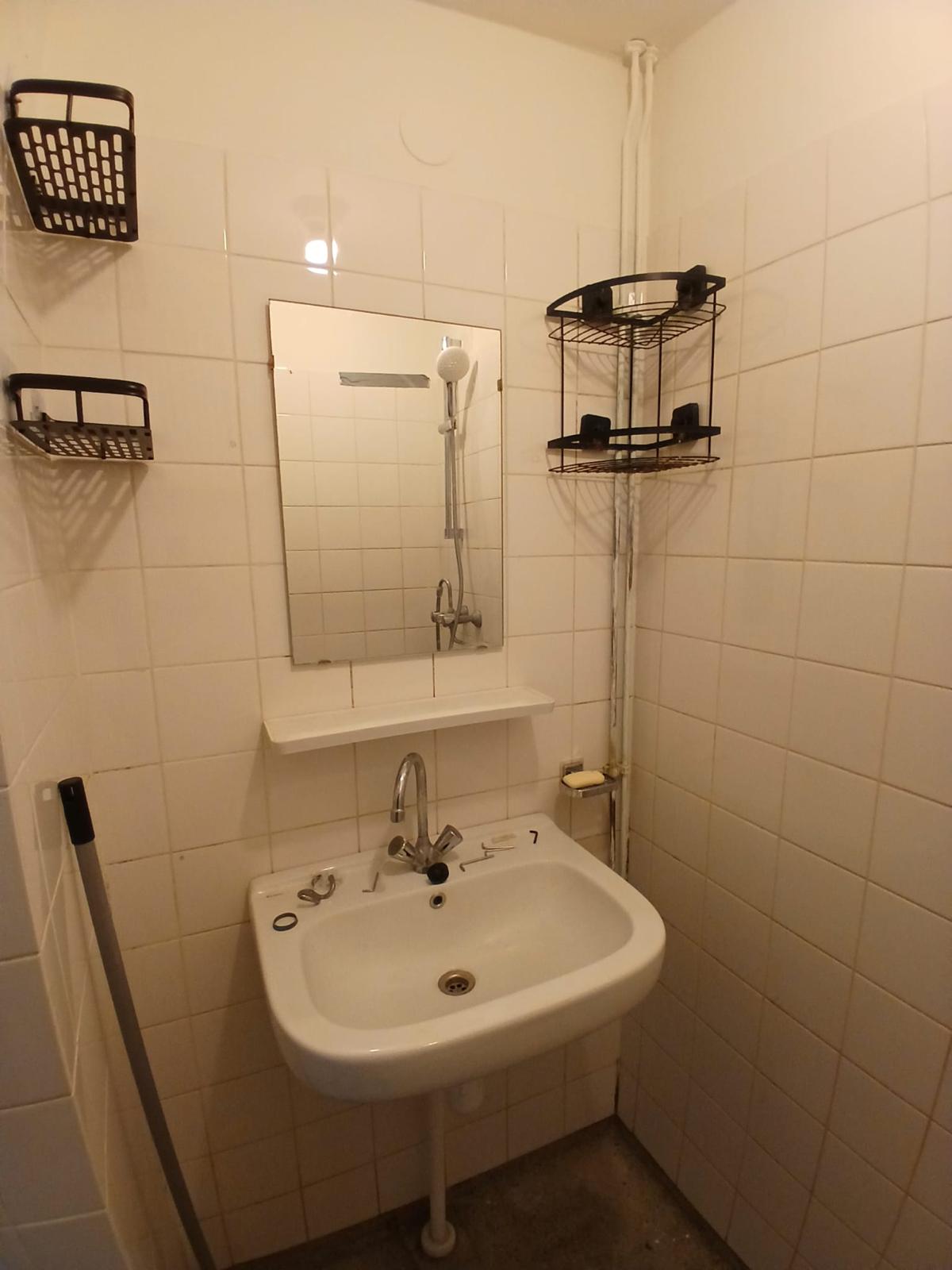 Badkamer met wastafel, kraan en aangesloten sanitair